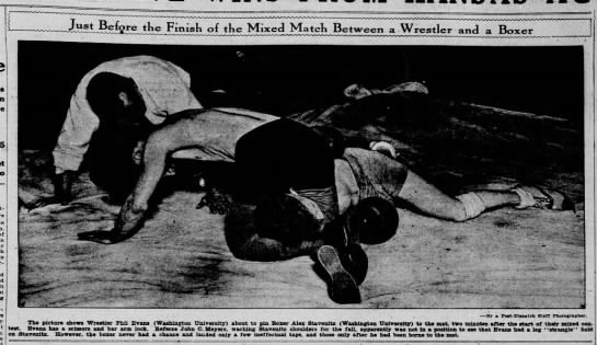 Wrestler Phil Evans controls boxer Alex Staventz on the mat under the watchful eyes of referee John C. Meyers. Both athletes were from Washington University in St. Louis Wrestler Phil Evans controls boxer Alex Staventz on the mat under the watchful eyes of referee John C. Meyers. Both athletes were from Washington University in St. Louis