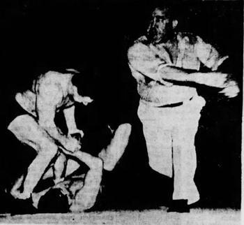 Lewis has just clouted Steele in the jaw for refusing to break his hold on Thesz. Lewis has just clouted Steele in the jaw for refusing to break his hold on Thesz.